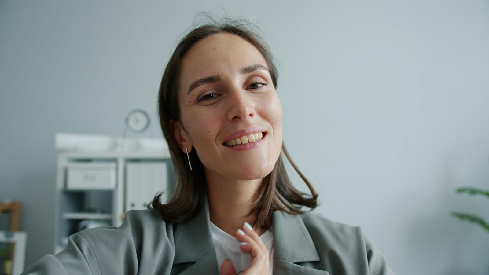 Point of view shot of cute businesswoman taking selfie in office smiling posing looking at camera indoors. Modern lifestyle, technology and happy people concept.