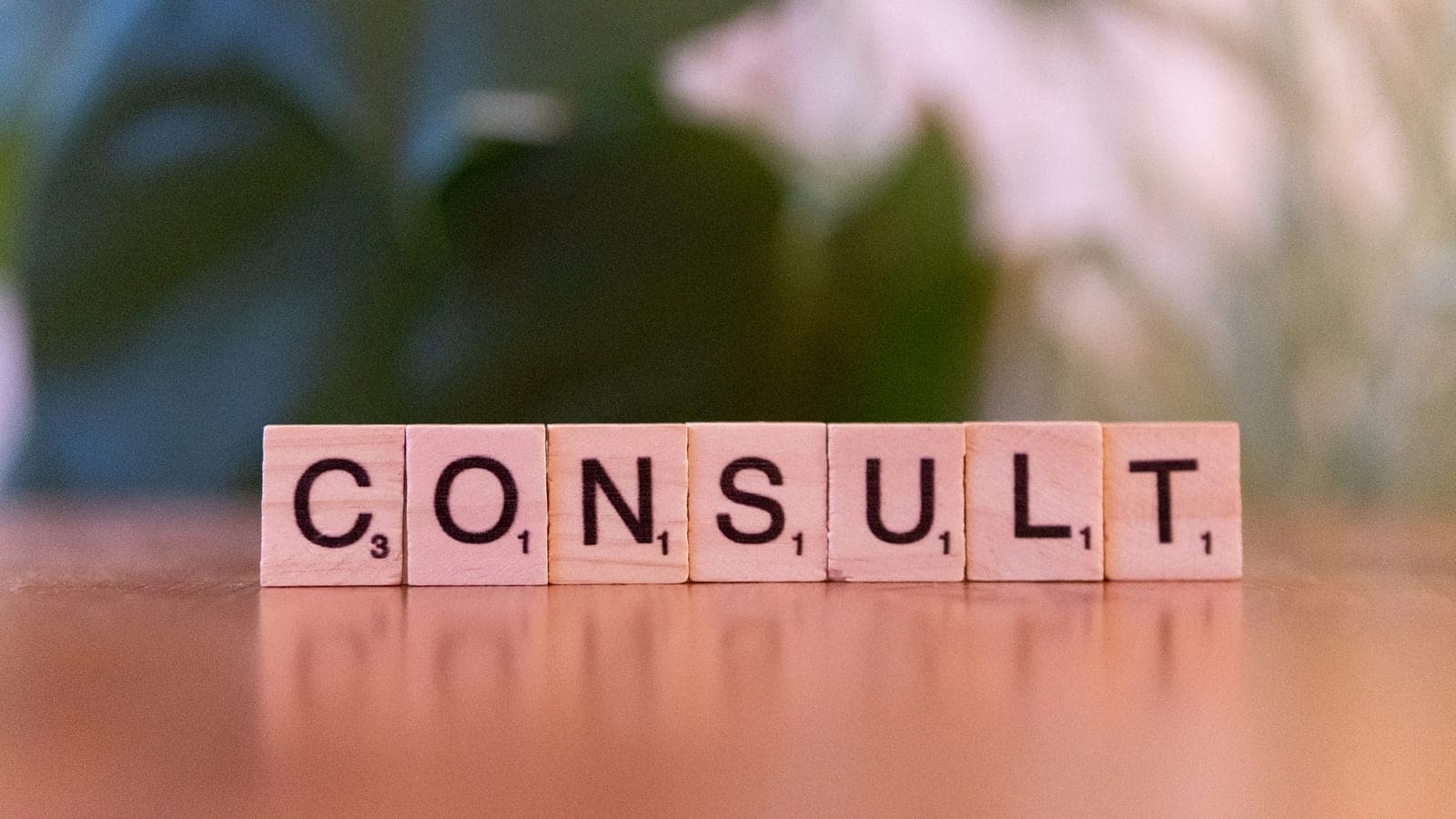 A wooden block spelling consulting on a table