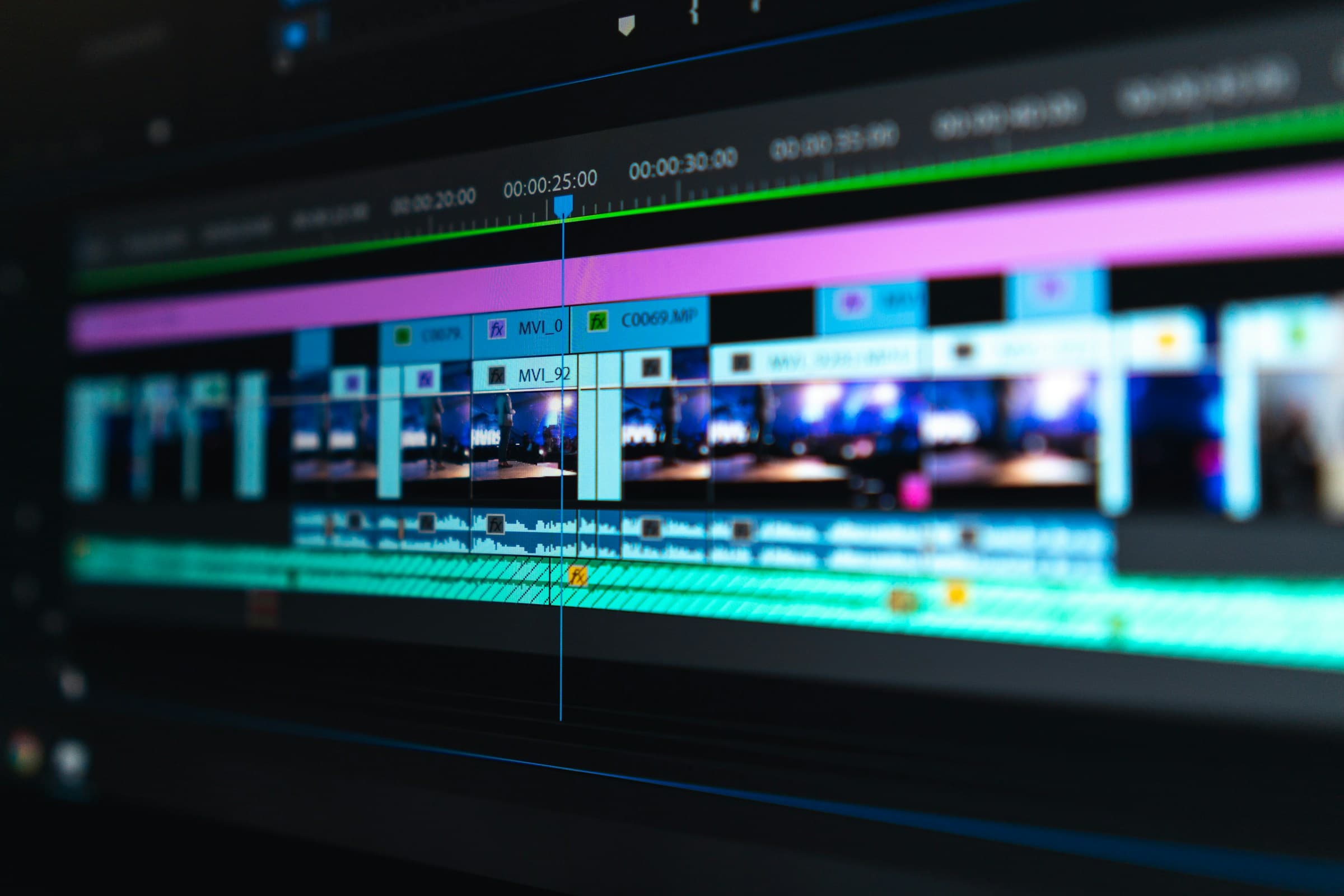 Close-up of a video editing timeline in professional editing software, showing colorful clip tracks and timecodes