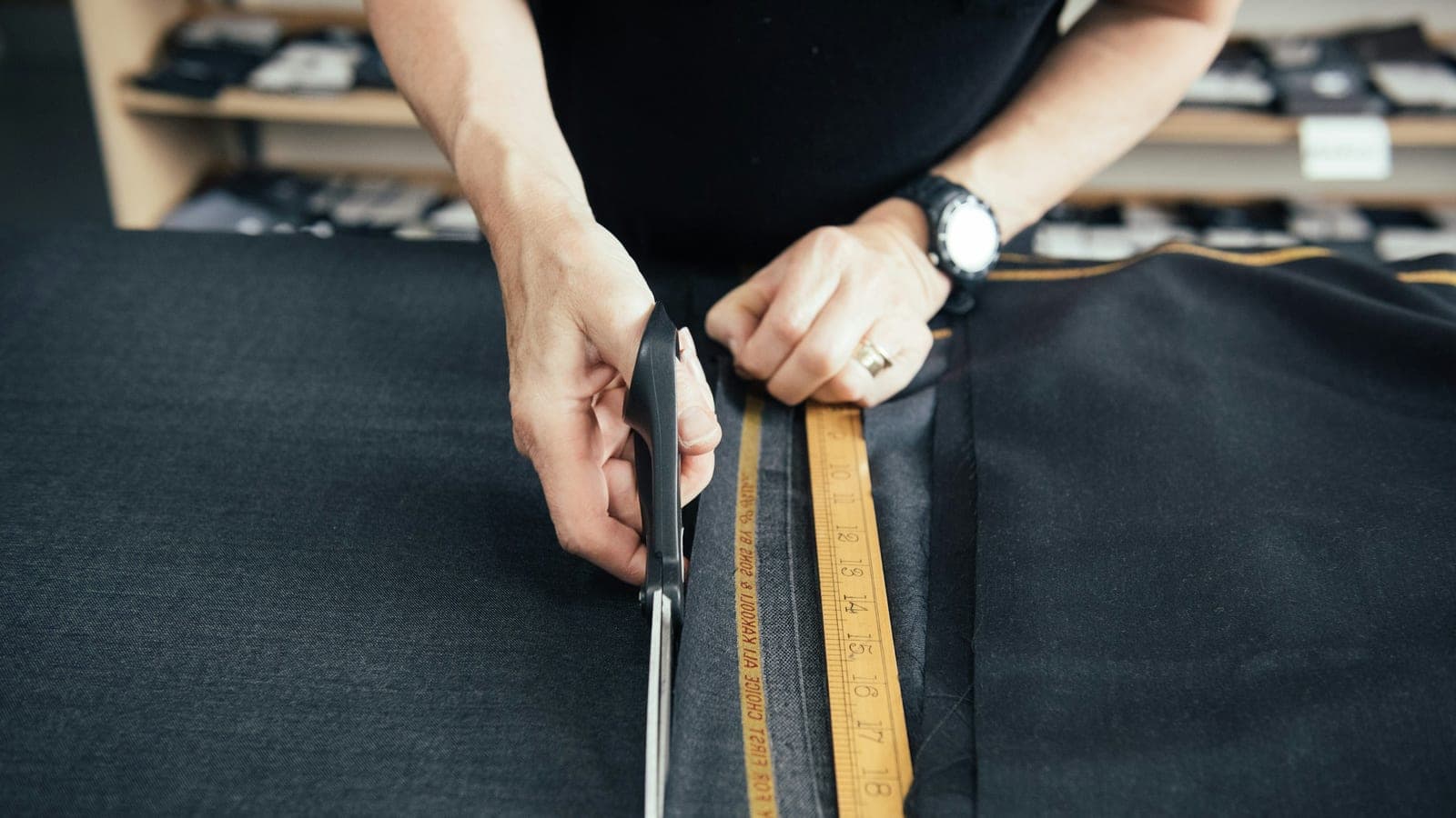 A tailor cutting luxury cloth for a suit. Cloth by Pepper Lee. Please credit https://pepperlee.co.uk/ when using this image.