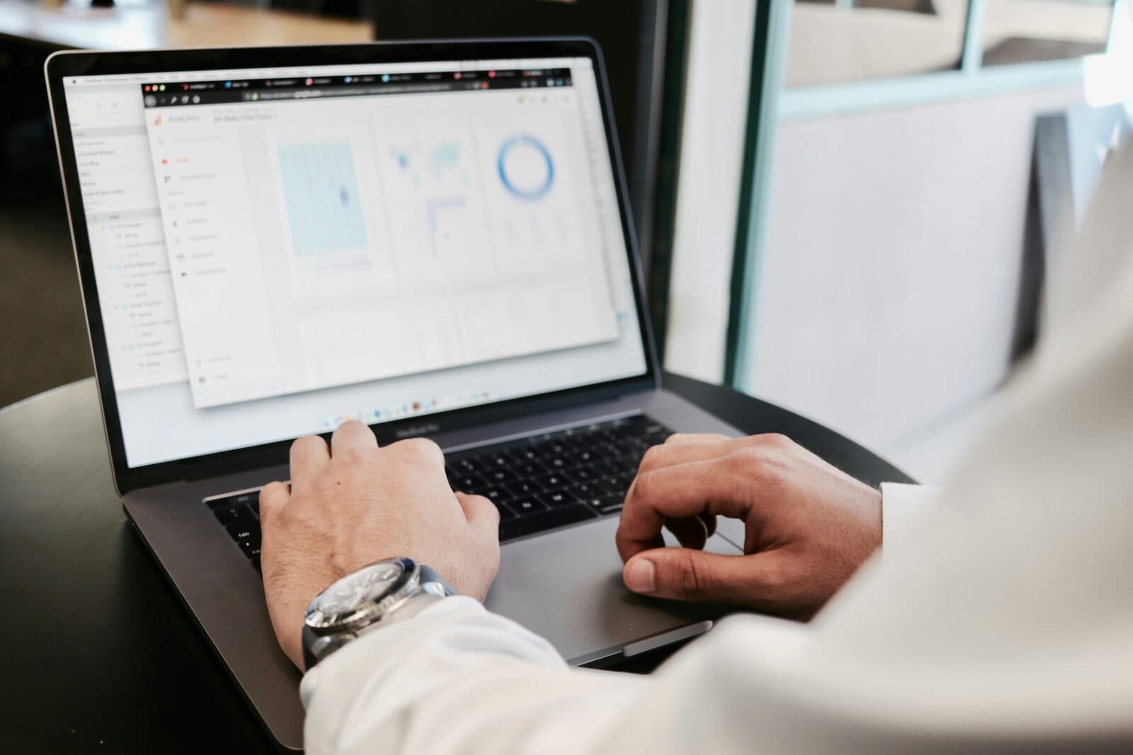 A professional in business attire working on a laptop in a corporate workspace, representing strategic advisory and executive decision-making