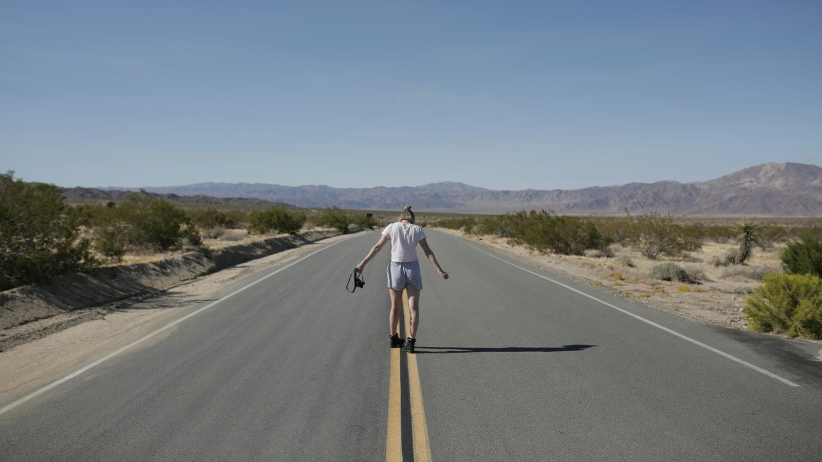A man riding a skateboard down the middle of a road