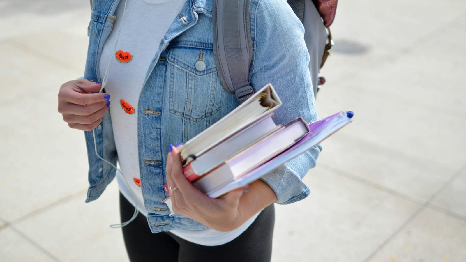 Woman wearing blue denim jacket holding book