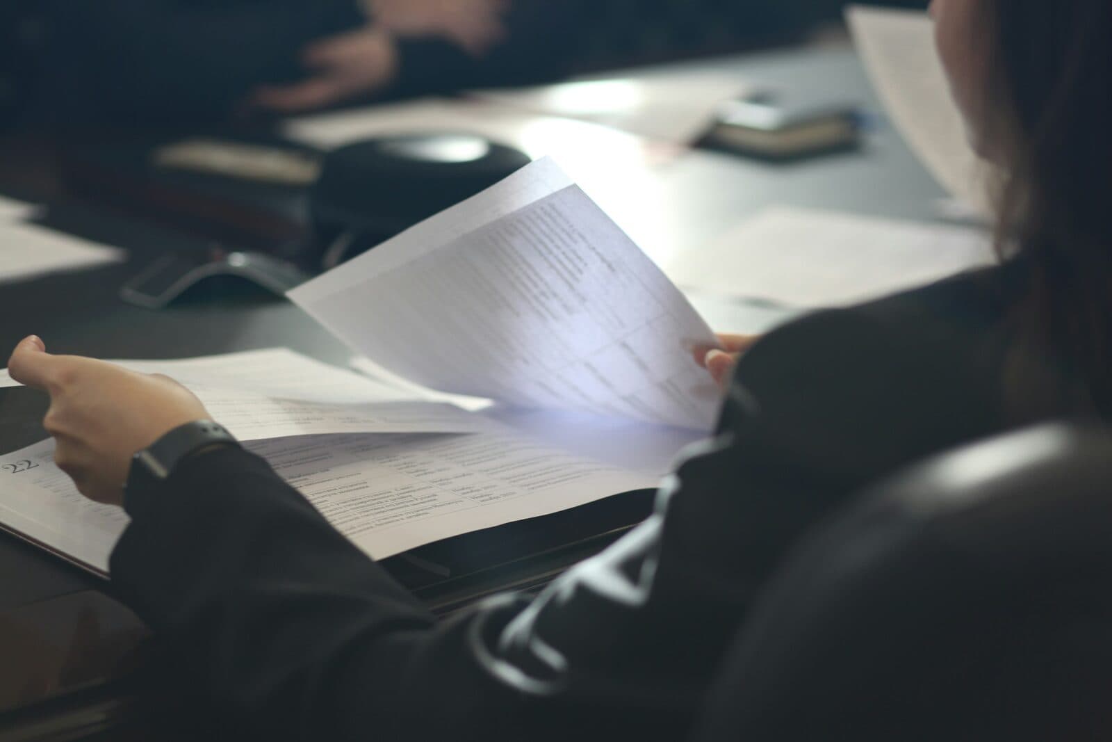 A professional advisor reviewing research documents at a desk in an office setting, representing the managed intelligence model for boutique advisory firms