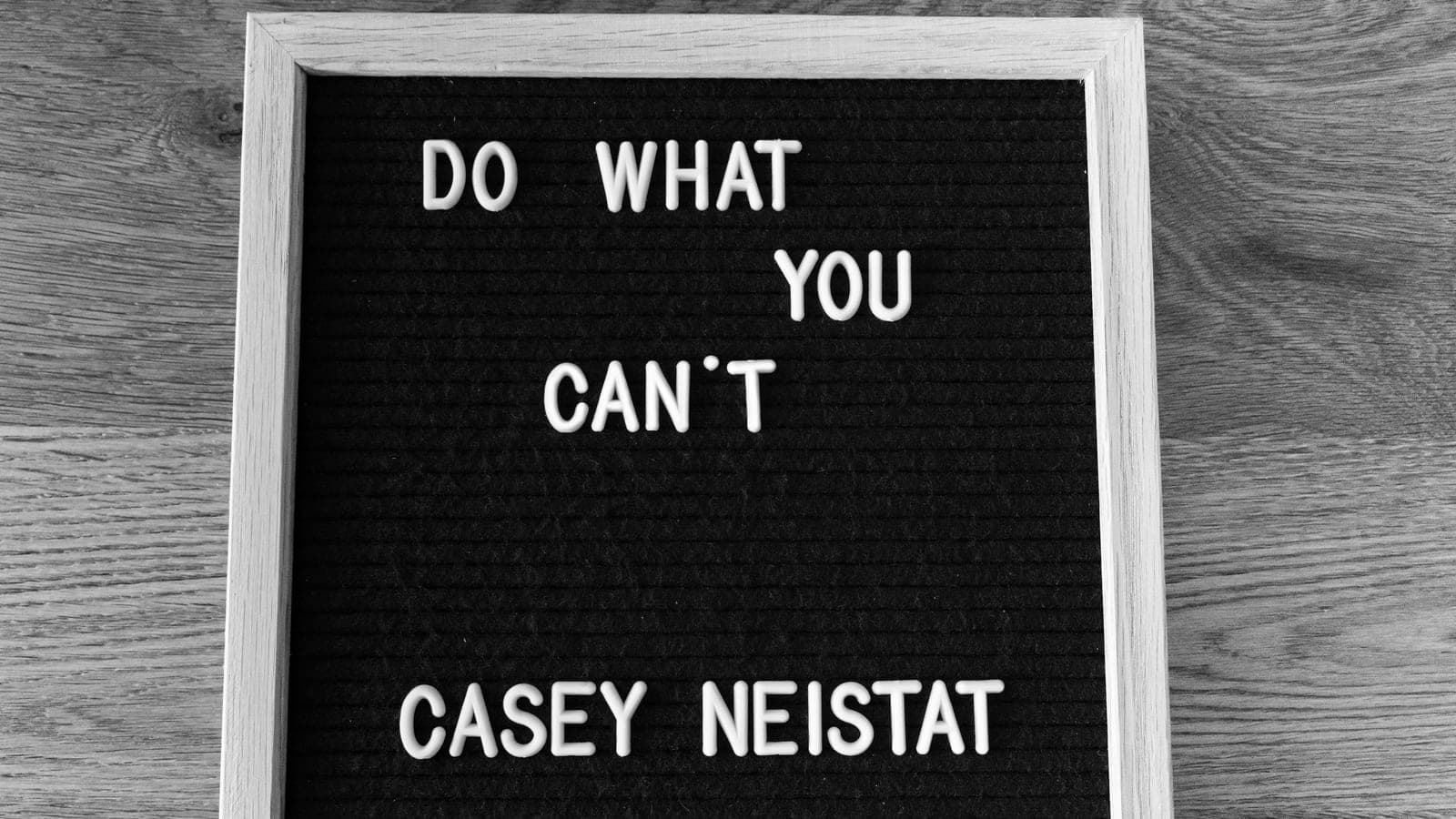 White wooden frame holding a motivational quote