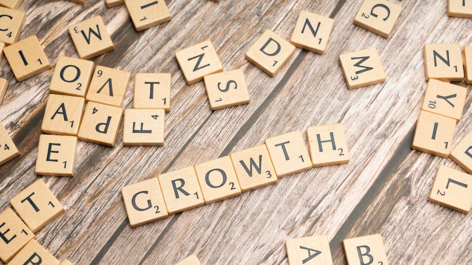 Scrabbled letters spelling growth on a wooden surface