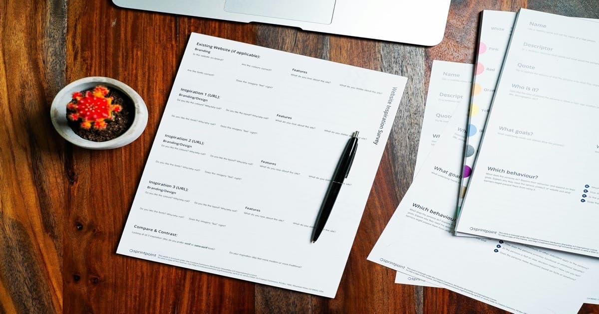 A person reviewing a printed business proposal at a desk with an open laptop — representing the organized engagement data layer that drives proposal quality in boutique advisory firms