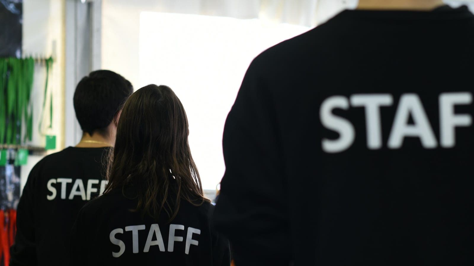 A group of people in black shirts standing in a room