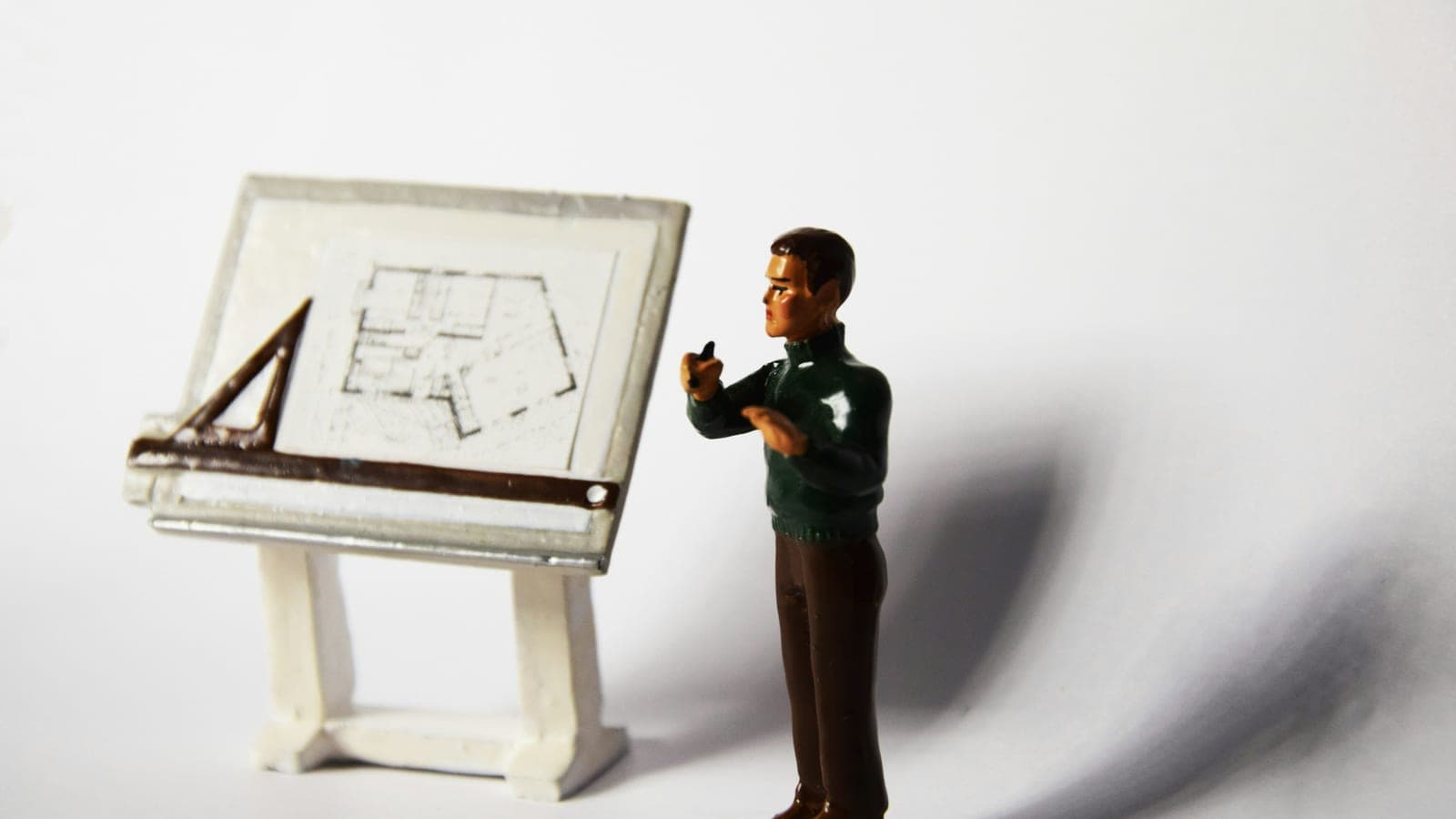 A toy man standing next to a miniature easel